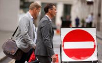 FILE PHOTO: People walk past a no entry sign in the City of London financial district amid the outbreak of the coronavirus disease (COVID-19)
