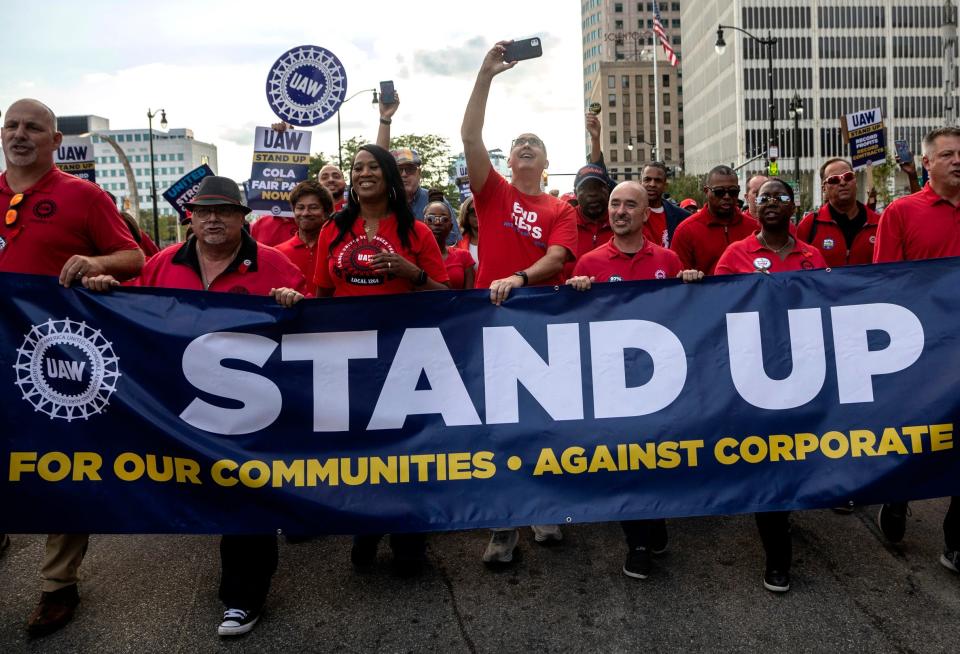 UAW President Shawn Fain takes a selfie and marches with dozens of United Auto Workers in Detroit on September 15, 2023.