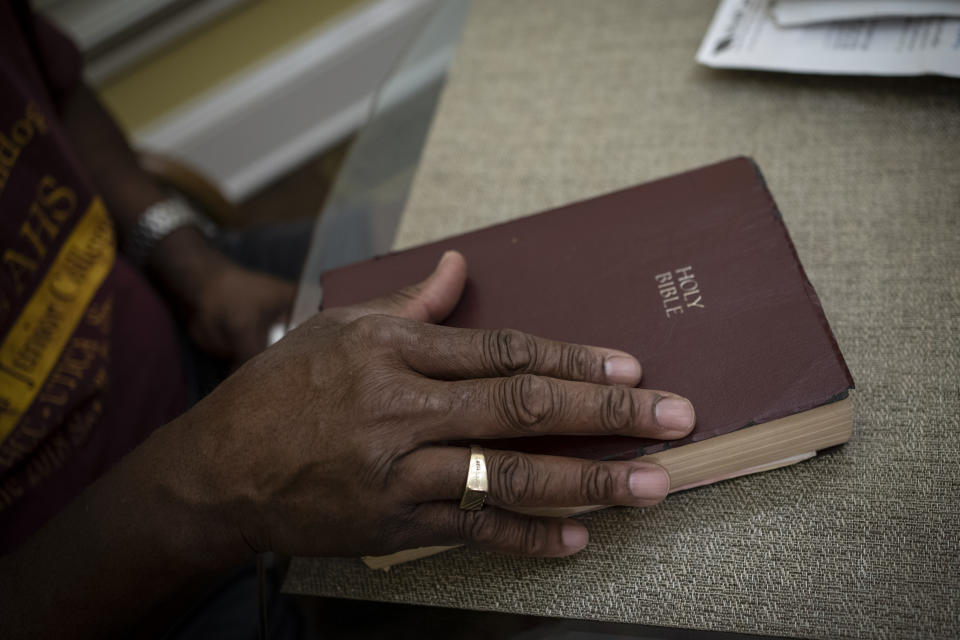 Mike Bishop closes his Bible after reading a passage from the Book of Psalms in Byram, Miss., on Thursday, Oct. 8, 2020. In early July, Bishop was hit by COVID-19. He was exhausted and achy, but never had to be hospitalized. But for Bonnie Bishop, his wife, coronavirus hit like a tsunami. (AP Photo/Wong Maye-E)