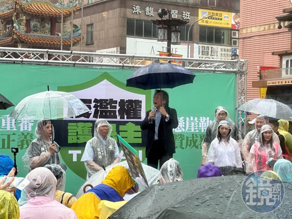 民進黨今天下午舉行台北場「反濫權護民主」街頭說明會，綠委王世堅無畏風雨，撐著傘撂台語致詞。