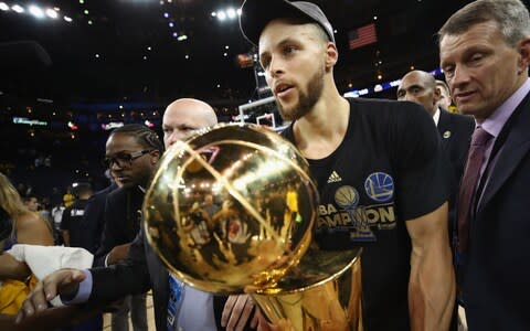 Stephen Curry #30 of the Golden State Warriors carries off the Larry O'Brien Championship Trophy after defeating the Cleveland Cavaliers 129-120 in Game 5 to win the 2017 NBA Finals at ORACLE Arena on June 12, 2017 in Oakland, California - Credit: GETTY IMAGES