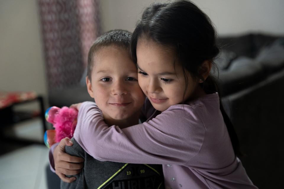 Alvira Arvizo hugs her younger brother, Adriel Arvizo, at their temporary home in Avondale, Arizona, on Nov. 18, 2022.