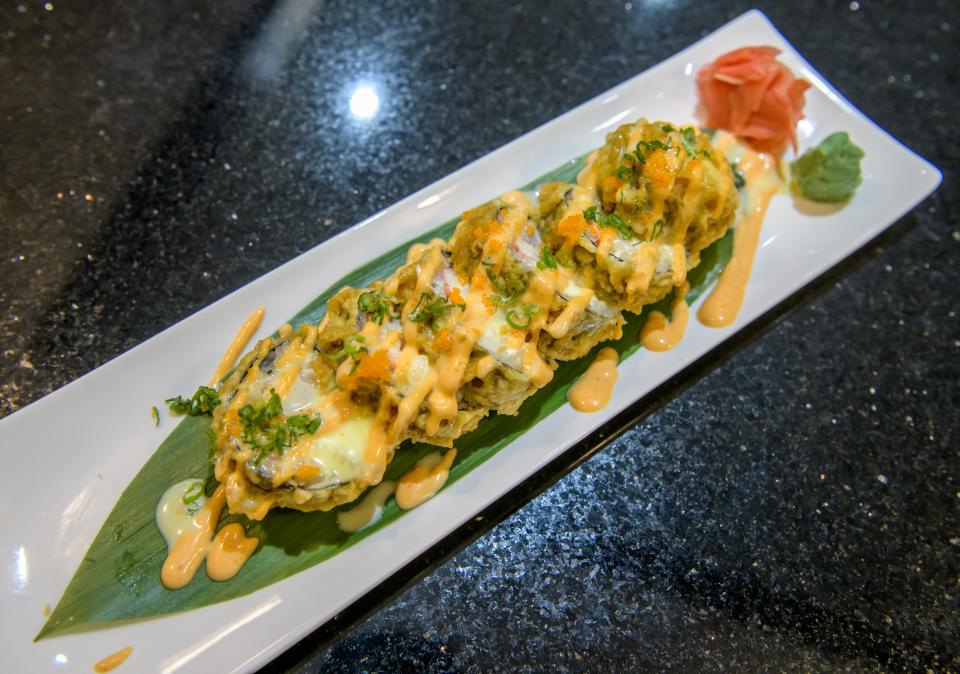 A Dynamite Roll at Oyama Sushi is a lightly fried roll with cream cheese, crab meat, mixed fish and avocado topped with masago, scallion, wasabi mayo and spicy mayo.