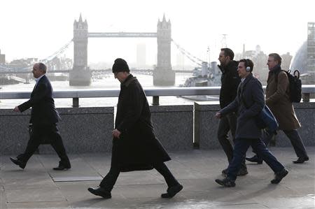 Tower Bridge is seen behind commuters as they walk across London Bridge during an Underground strike in London February 5, 2014. REUTERS/Eddie Keogh