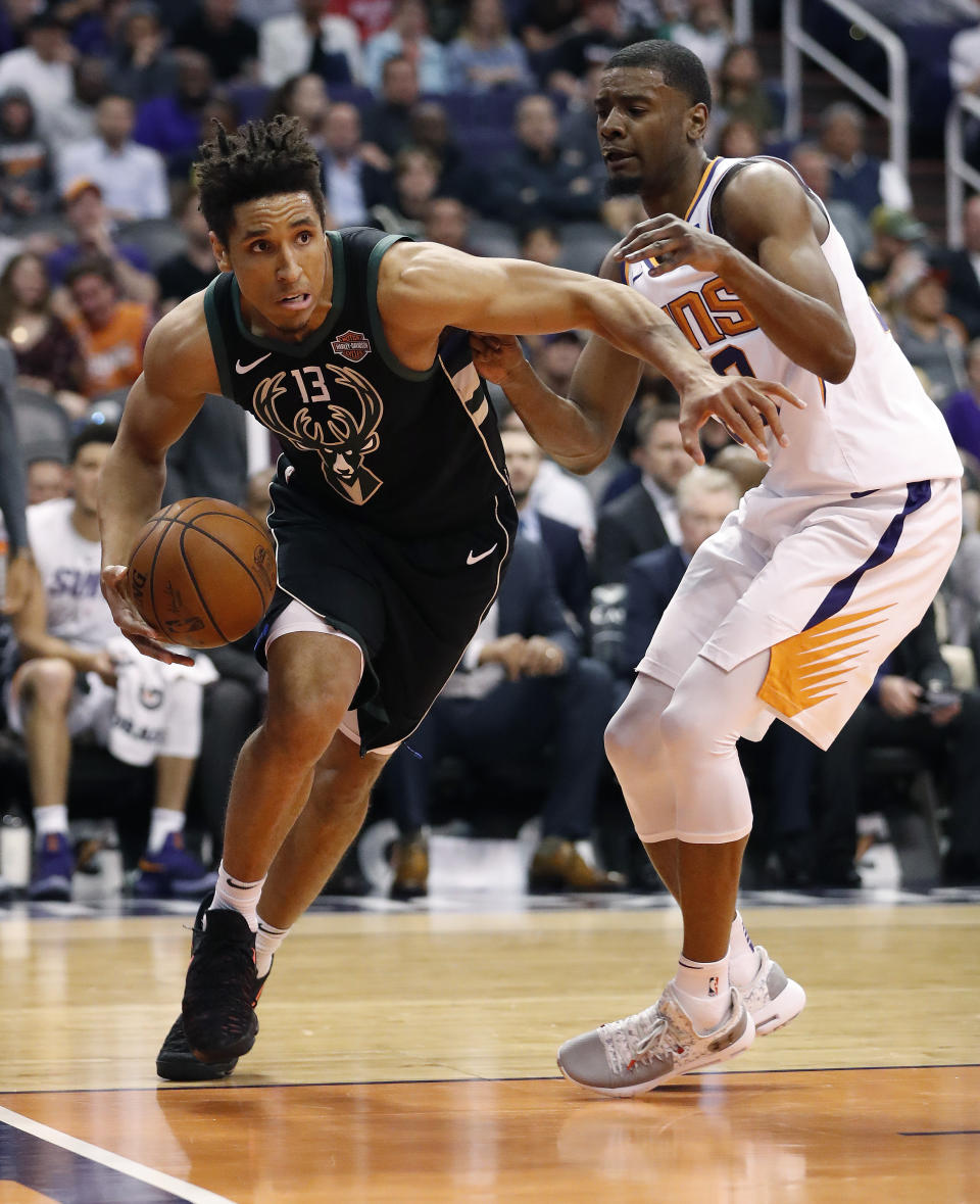 Milwaukee Bucks guard Malcolm Brogdon (13) drives past Phoenix Suns forward Josh Jackson during the first half of an NBA basketball game, Monday, March 4, 2019, in Phoenix. (AP Photo/Matt York)