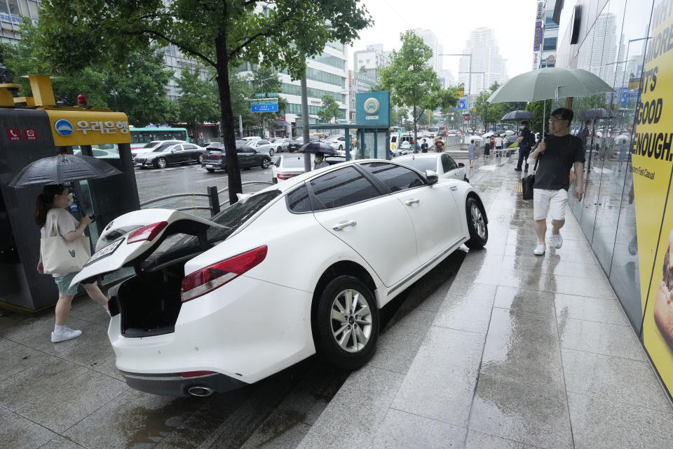 A vehicle is damaged on the sidewalk after floating in heavy rainfall in Seoul, South Korea, Tuesday, Aug. 9, 2022. Heavy rains drenched South Korea's capital region, turning the streets of Seoul's affluent Gangnam district into a river, leaving submerged vehicles and overwhelming public transport systems. (AP Photo/Ahn Young-joon)