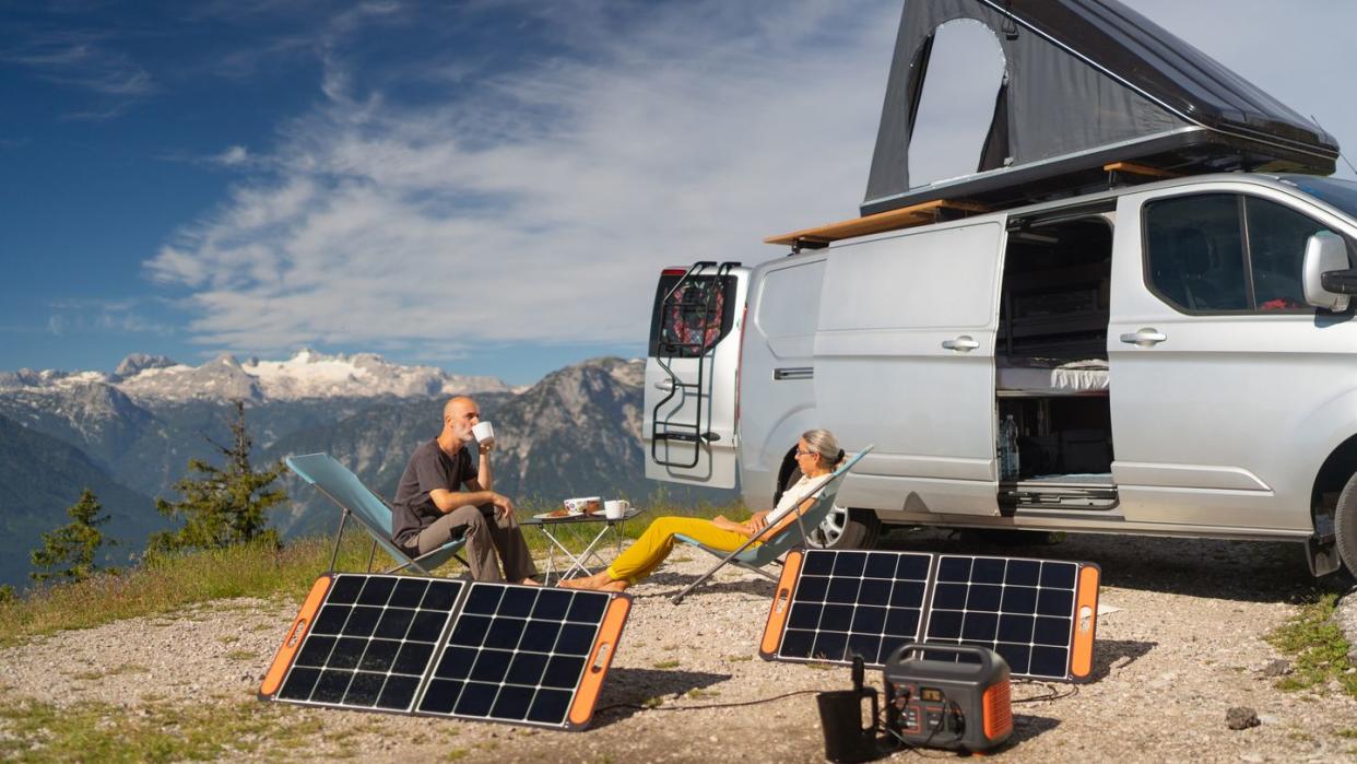 self supporter mature couple on camping vacations in the mountains enjoying breakfast