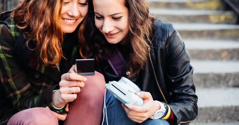 young women making instant photos with instant camera