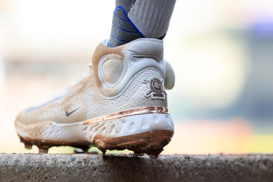 Cincinnati Reds' Jonathan India wears cleats honoring Jackie Robinson as he stands on the dugout steps during the second inning of a baseball game against the Philadelphia Phillies in Cincinnati, Saturday, April 15, 2023. (AP Photo/Aaron Doster)