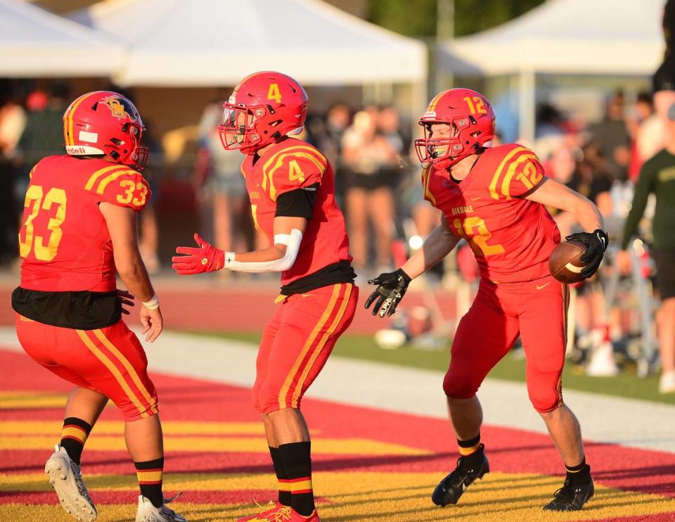 Oakdale’s Wes Burford (12) celebrates with teammates after scoring a touchdown during a game between Oakdale High School and Sonora High School at Oakdale High School in Oakdale California CA on August 18, 2023.