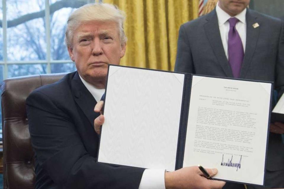 Donald Trump signing an executive order on his first full business day in office (Getty Images)