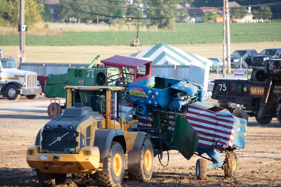 An incapacitated combine is carried out of the arena during the combine demolition derby event at the 75th Annual Monroe County Fair.