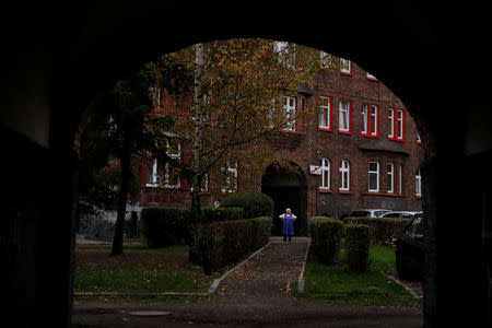 A woman stands in a courtyard in Nikiszowiec district in Katowice, Poland, October 17, 2018. REUTERS/Kacper Pempel