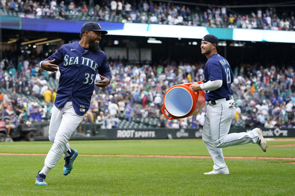 Seattle Mariners right fielder Teoscar Hernandez (35) runs away from first baseman Ty France after being doused as they celebrate the Mariners' 5-4 win over the Oakland Athletics in a baseball game Wednesday, Aug. 30, 2023, in Seattle. (AP Photo/Lindsey Wasson)