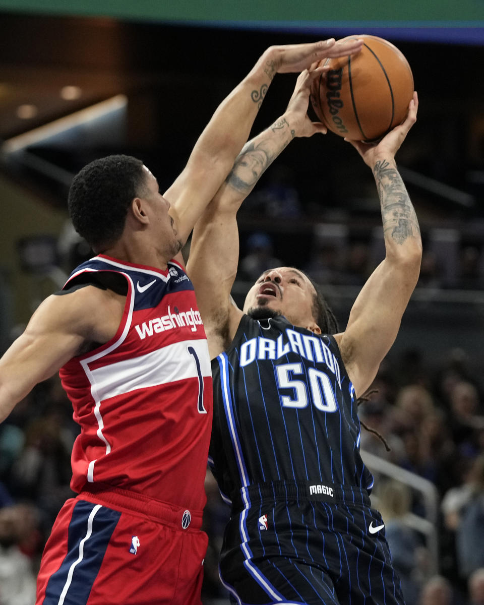 Washington Wizards guard Johnny Davis (1) blocks a shot attempt by Orlando Magic guard Cole Anthony (50) during the first half of an NBA basketball game Friday, Dec. 1, 2023, in Orlando, Fla. (AP Photo/John Raoux)