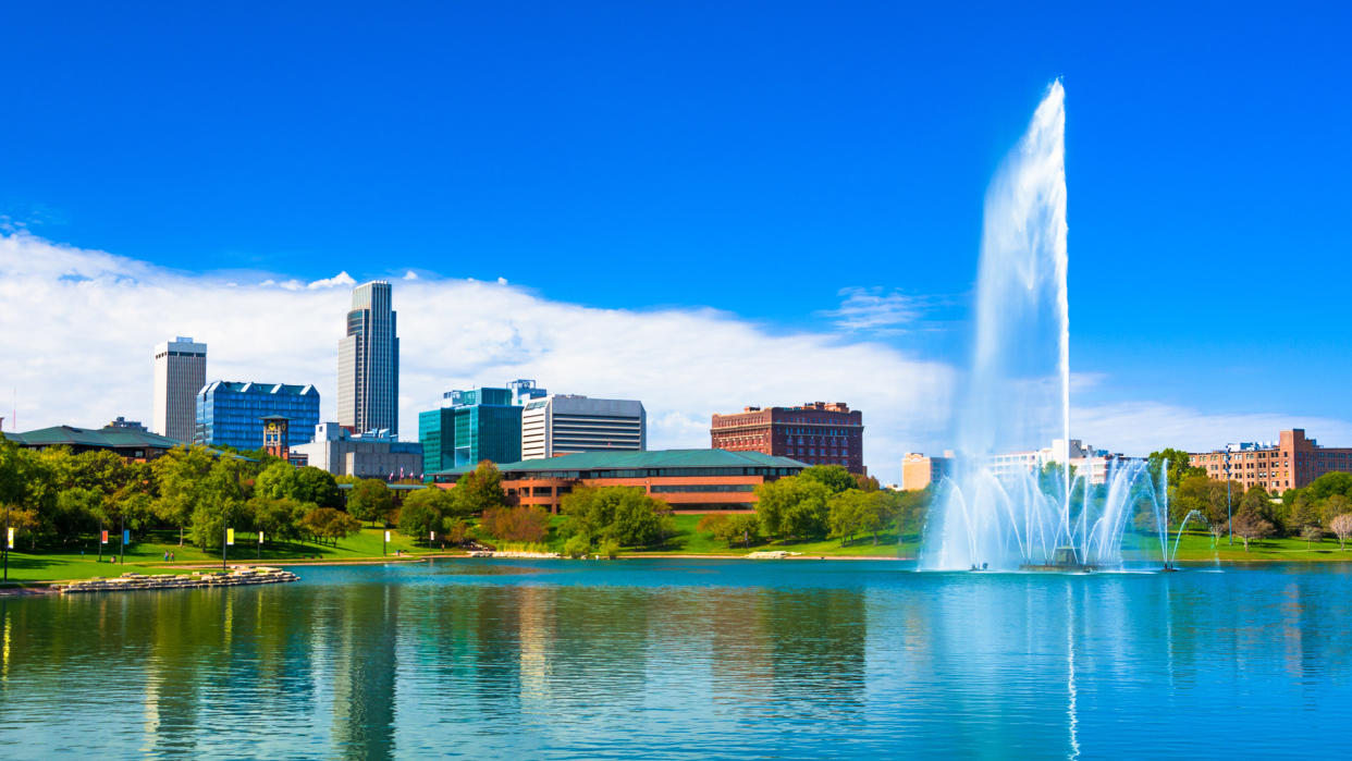 Downtown Omaha skyline with a Lake and a large ornate fountain in the Heartland of America Park.