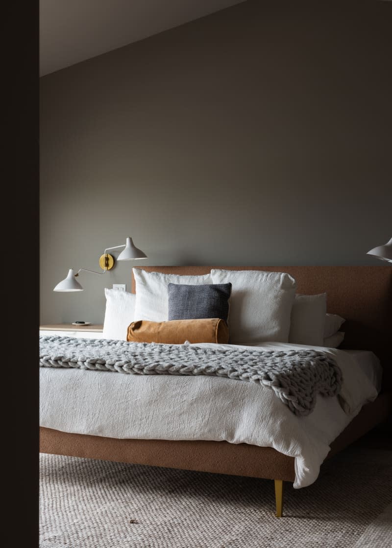 Bedroom with gray walls, wood frame bed with white and gray bedding