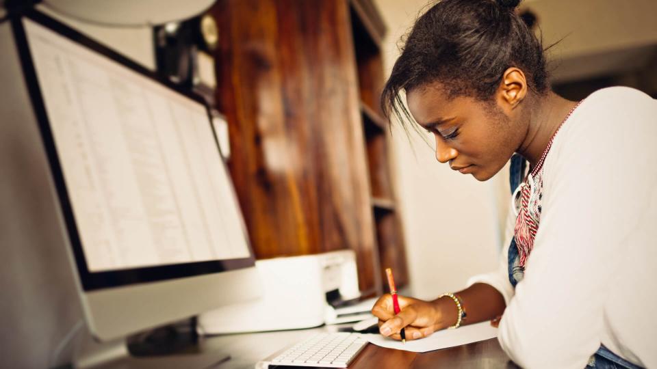 Young African woman studying home.