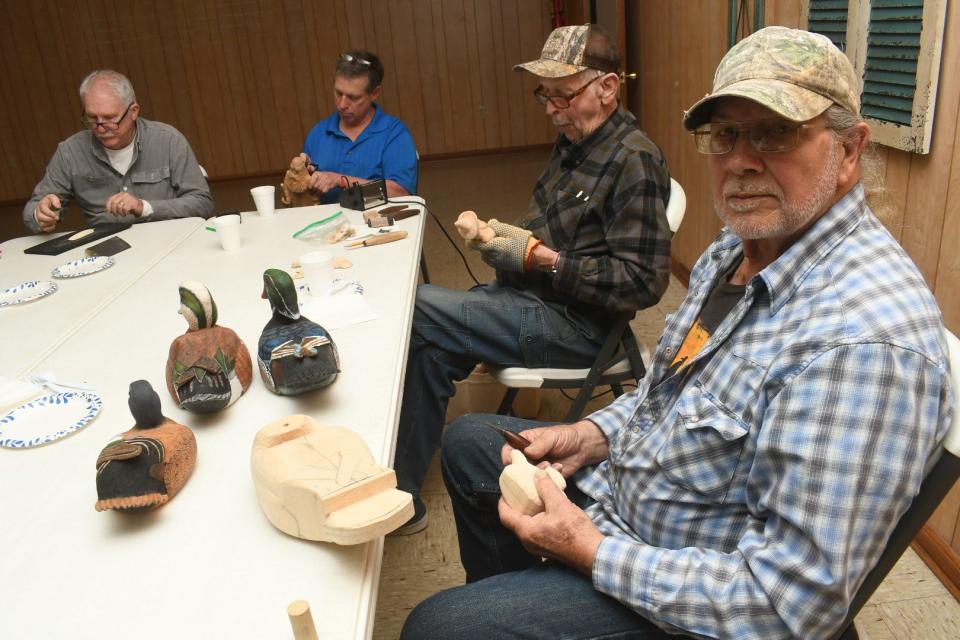 Sylvan “T-Boy” LaBorde (front) carves a duck decoy while Jimmy Crooks (second from right) and John Wilks, Jr., carve caricatures. Robert Willie is the newest member of The Wood Artisan Guild of the Cenla and learned about to carve from the group members. LaBorde and Crooks are champion carvers.