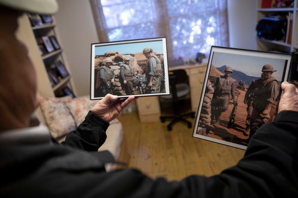 Dr. Joe Wolfe holds up photos of himself in Khe Sanh for the photographer inside his home in Dyersburg, Tenn., on Friday, January 27, 2023. Wolfe served as a medic in the 3rd Medical Battalion in Khe Sanh during the Vietnam War. 