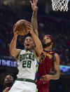 Milwaukee Bucks guard Lindell Wigginton goes to the basket against Cleveland Cavaliers forward Lamar Stevens in the first half of an NBA basketball game, Sunday, April 10, 2022, in Cleveland. (AP Photo/David Dermer)