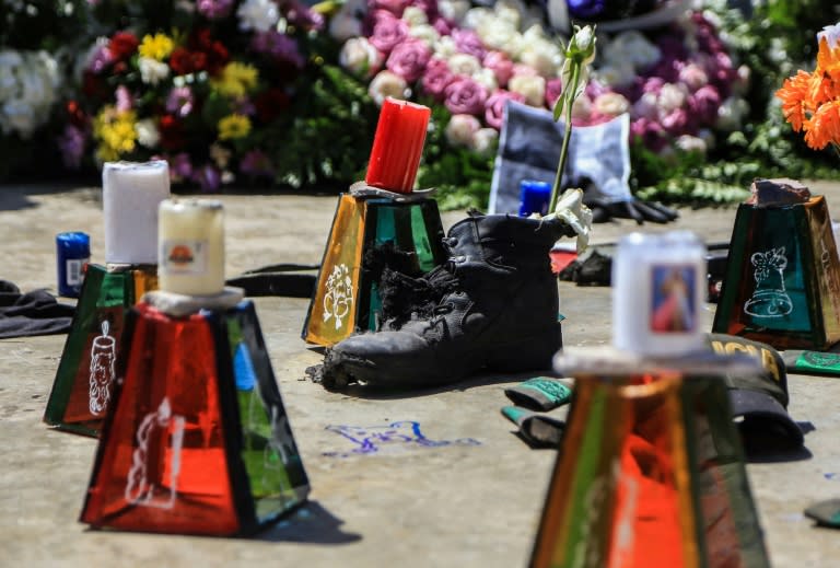 Candles, flowers and a shoe mark a memorial to police killed in an attack attributed to the ELN, the country's last leftist guerrilla group