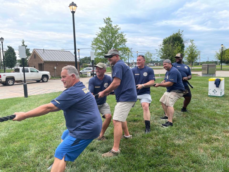 Members of the Knox County Sheriff's Office are ready for tug-of-war with Rural Metro Fire at the Food Truck Freedom Field Day event held at Mayor Ralph McGill Plaza in Farragut Saturday, Aug. 20, 2022. From left: Brad Hall, Clay Atherton, Denver Scalf, Joshua Hodge, Jeremy McCord, D’Brian Varnado.