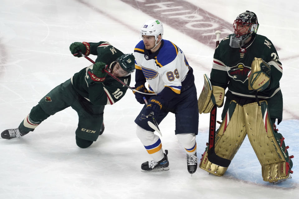 Minnesota Wild's Tyson Jost (10) tries to hold back St. Louis Blues' Pavel Buchnevich (89) as he and Wild goalie Marc-Andre Fleury, right, defend in the first period of Game 5 of an NHL hockey Stanley Cup first-round playoff series, Tuesday, May 10, 2022, in St. Paul, Minn. (AP Photo/Jim Mone)