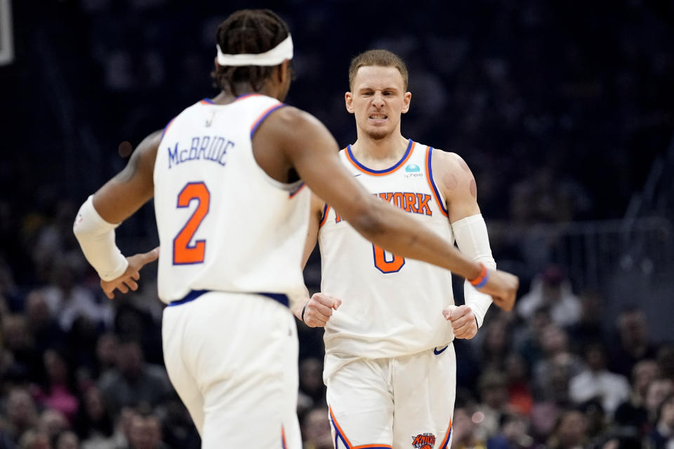 New York Knicks guard Donte DiVincenzo, right, and guard Miles McBride (2) celebrate in the first half of an NBA basketball game against the Cleveland Cavaliers, Sunday, March 3, 2024, in Cleveland. (AP Photo/Sue Ogrocki)