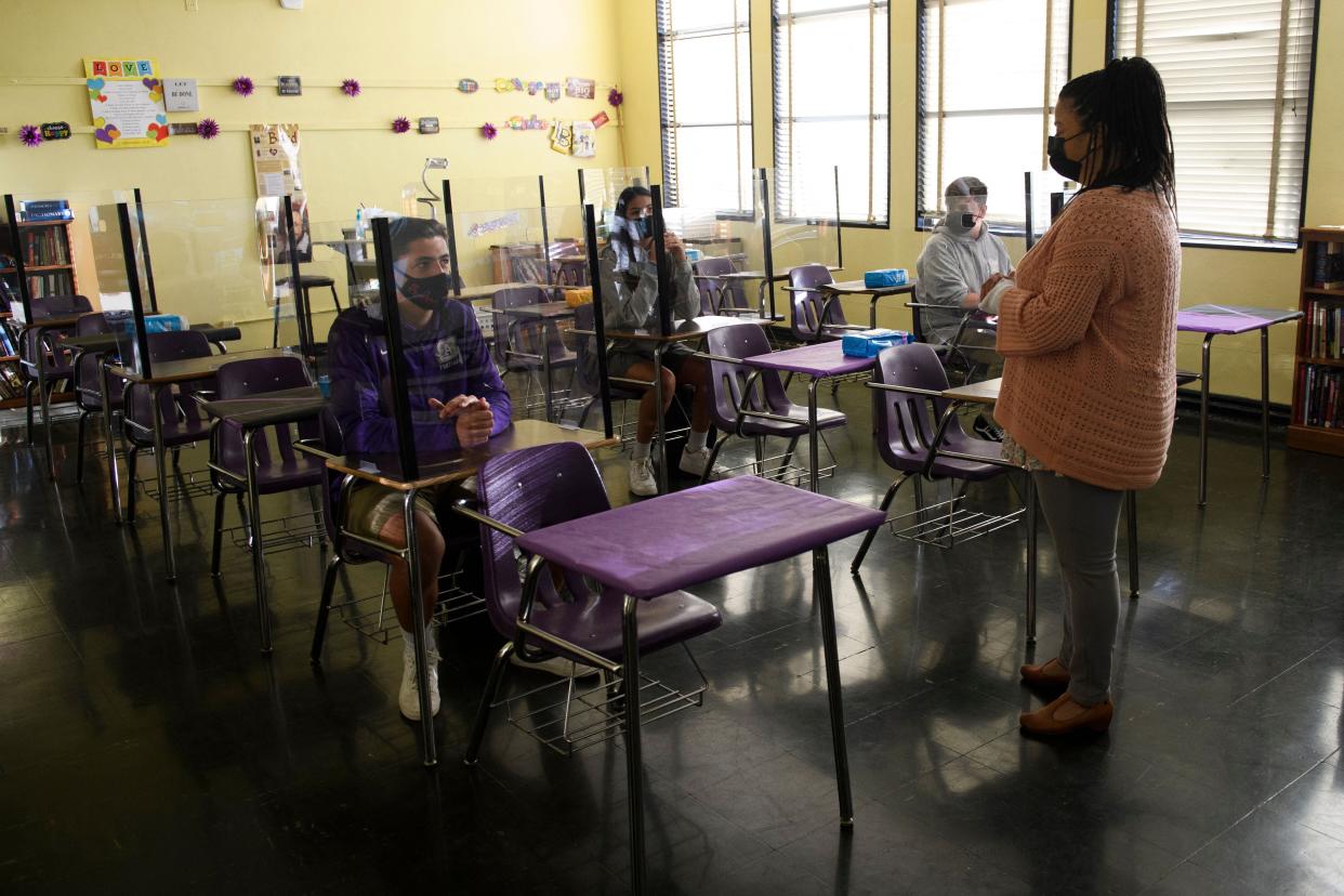 A teacher speaks with students as they return to in-person learning at St. Anthony Catholic High School during the Covid-19 pandemic on March 24, 2021 in Long Beach, California. A record-breaking level of US workers are leaving their jobs for new roles. (AFP via Getty Images)