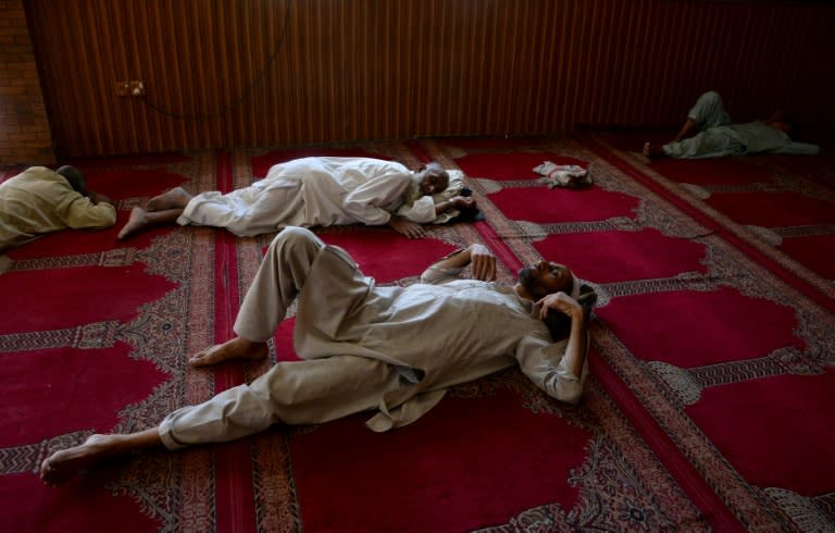 Afghan Muslim men sleep as they wait to break their fast at a mosque during the first day of the Islamic holy month of Ramadan in Jalalabad on May 27, 2017