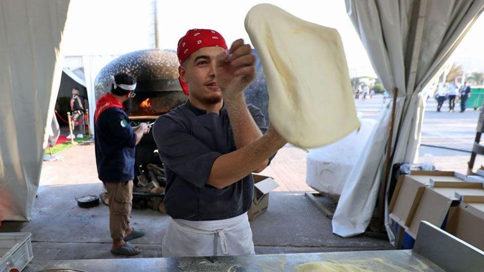 An image of a man tossing a pizza in Algiers, Algeria - Monday 5 August 2024