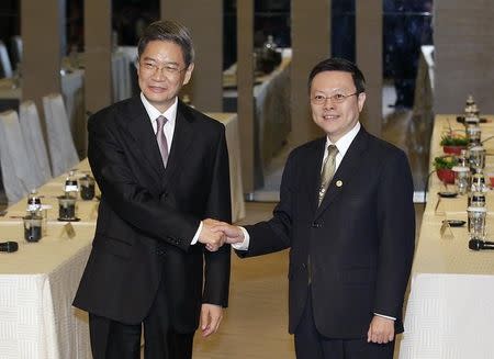 Zhang Zhijun (L), director of China's Taiwan Affairs Office, shakes hands with Taiwan's Mainland Affairs Council minister Wang Yu-chi in Taoyuan June 25, 2014. REUTERS/Pichi Chuang