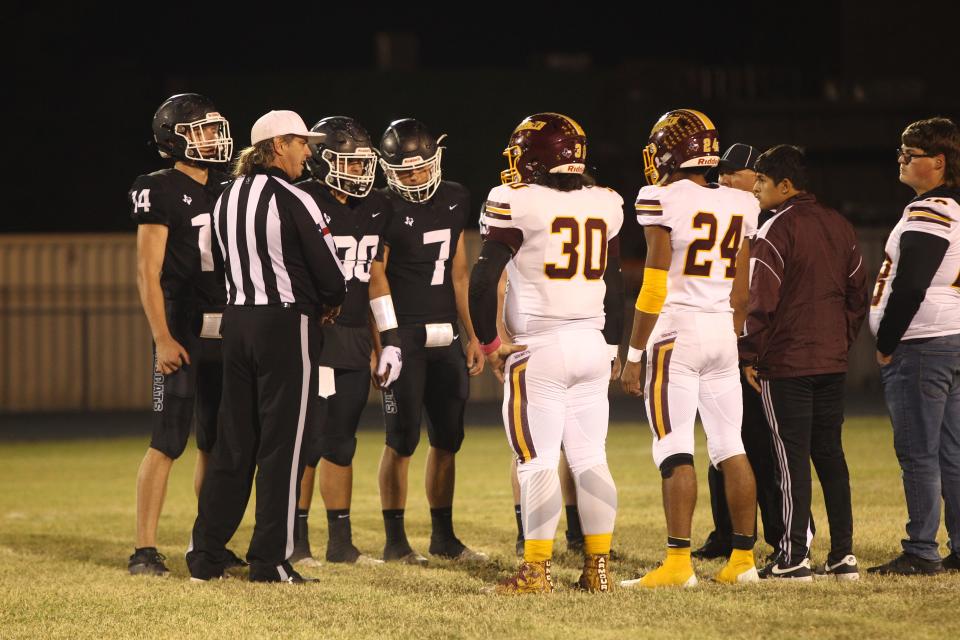 Water Valley High School team captains Gabe Smith, left to right in black, Josiah Padilla and Canon Wiese meet the Lometa Hornet captains at midfield before the Class 1A Division I regional semifinal playoff football game Friday, Nov. 19, 2021 at Sanders Field in Eden.