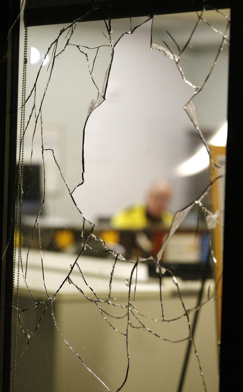 A window of the the VCU Grace and Broad Resident Center is left shattered as protesters marched through the area and squared off with police in Richmond, Va., Saturday, July 25, 2020. (James H Wallace/Richmond Times-Dispatch via AP)