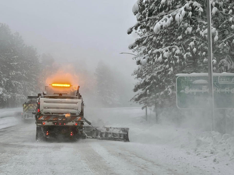 In this image released by Caltrans District 3, a snow plow drives past the Sly Park Rd., exit in El Dorado County, Calif., Tuesday, Feb. 28, 2023, Beleaguered Californians got hit again Tuesday as a new winter storm moved into the already drenched and snow-plastered state, with blizzard warnings blanketing the Sierra Nevada and forecasters warning residents that any travel was dangerous. (Caltrans District 3 via AP)