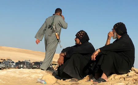 FILE PHOTO: Monks look at an armed policeman following an attack by gunmen on a group of Coptic Christians travelling to a monastery in southern Egypt, in Minya, May 26, 2017. REUTERS/Mohamed Abd El Ghany/File Photo