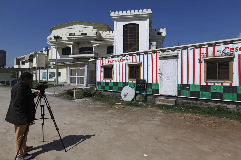 A Pakistani cameraman films a school and dispensary sealed by authorities beside a mosque belong to a banned religious group, in Islamabad, Pakistan, Wednesday, March 6, 2019. Pakistan on Wednesday continued a crackdown on seminaries, mosques and hospitals belonging to outlawed groups, saying the actions were part of the government efforts aimed at fighting terrorism, extremism and militancy. (AP Photo/Anjum Naveed)