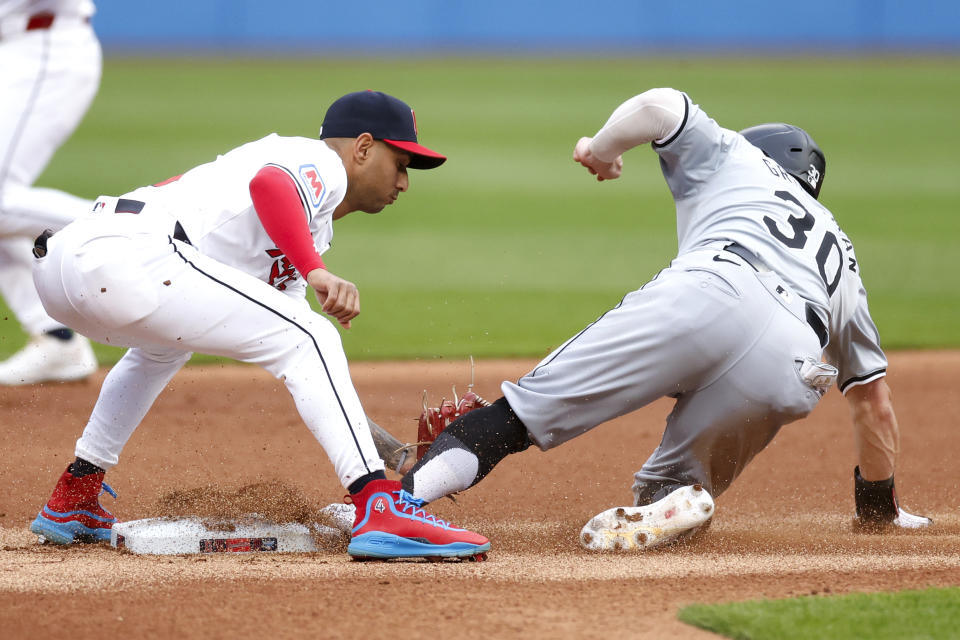 Chicago White Sox's Robbie Grossman (30) steals second base as Cleveland Guardians shortstop Brayan Rocchio attempts to make a tag during the first inning of a baseball game, Wednesday, April 10, 2024, in Cleveland. (AP Photo/Ron Schwane)