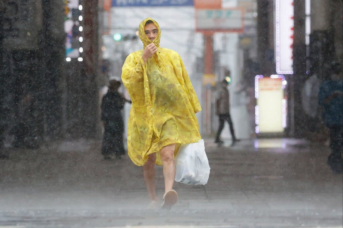 A man makes his way through heavy rain in  Kagoshima  (AP)