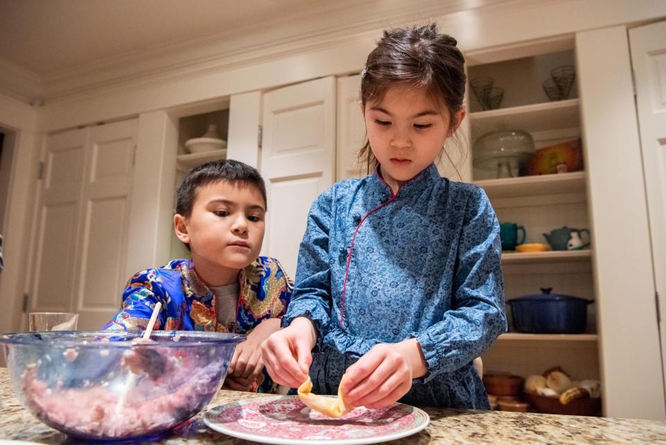 Ethan Robinson, 9, watches as his sister, Madison, 6, makes wontons for the Lunar New Year in their Plumstead home on Thursday, January 19, 2023.