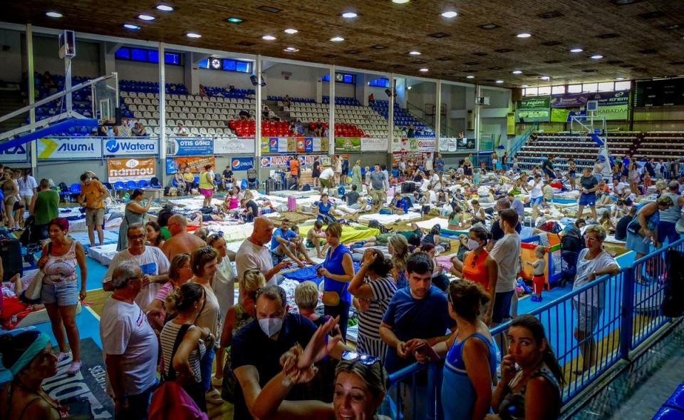 Tourists are sheltered in a stadium after being evacuated following a wildfire on the island of Rhodes (via REUTERS)