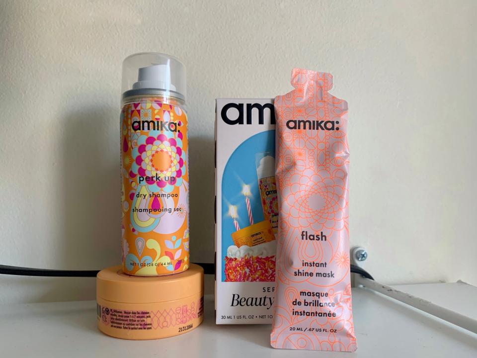 Three Amika products in front of a white wall