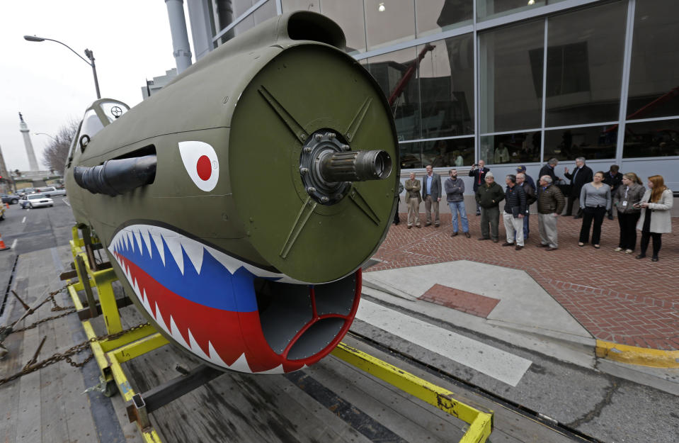 A restored P-40 Curtiss Warhawk fighter plane, one of only 32 known remaining in the world, arrives on a flatbed truck for permanent display at the National World War II Museum in New Orleans, Monday, Feb. 3, 2014. The plane, painted in the scheme of the famed Flying Tigers, will be displayed in the museum’s new pavilion, Campaigns of Courage: European and Pacific Theaters. (AP Photo/Gerald Herbert)