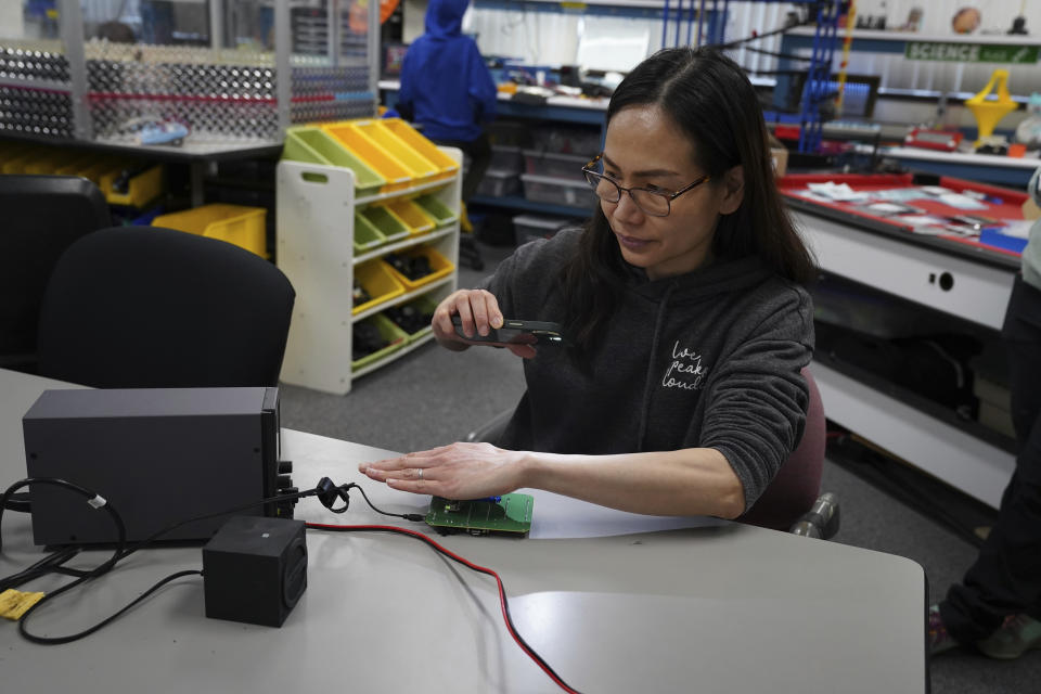 Katherine Tso tests components of a LightSound device at the New England Sci-Tech education center in Natick, Mass., on March 2, 2024. When the sun is bright, the device plays high flute notes. As the moon begins to cover the sun, the mid-range notes are those of a clarinet. Darkness is rendered by a low clicking sound. (AP Photo/Mary Conlon)