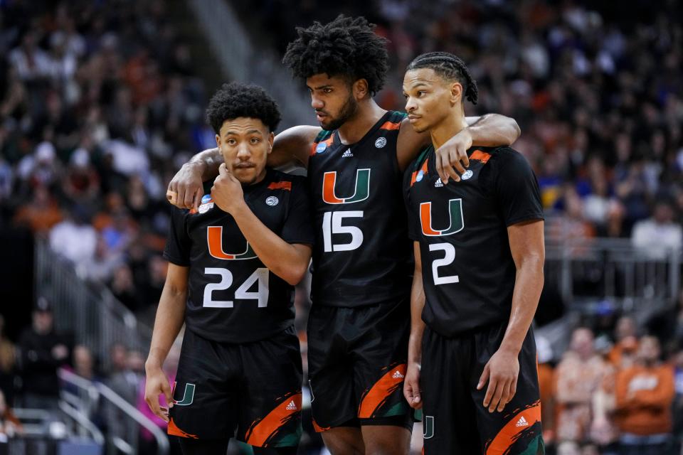 Miami guard Nijel Pack (24), forward Norchad Omier (15), and guard Isaiah Wong (2) stand on the court during the team's defeat of Texas in the Midwest Regional championship game of the NCAA men's tournament at the T-Mobile Center.