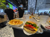 Workers prepare to serve burgers at the first Beijing outlet for Shake Shack in Beijing on Wednesday, Aug. 12, 2020. The U.S. headquartered burger chain is opening its first Beijing restaurant at a time when China and the U.S. are at loggerheads over a long list of issues. (AP Photo/Ng Han Guan)