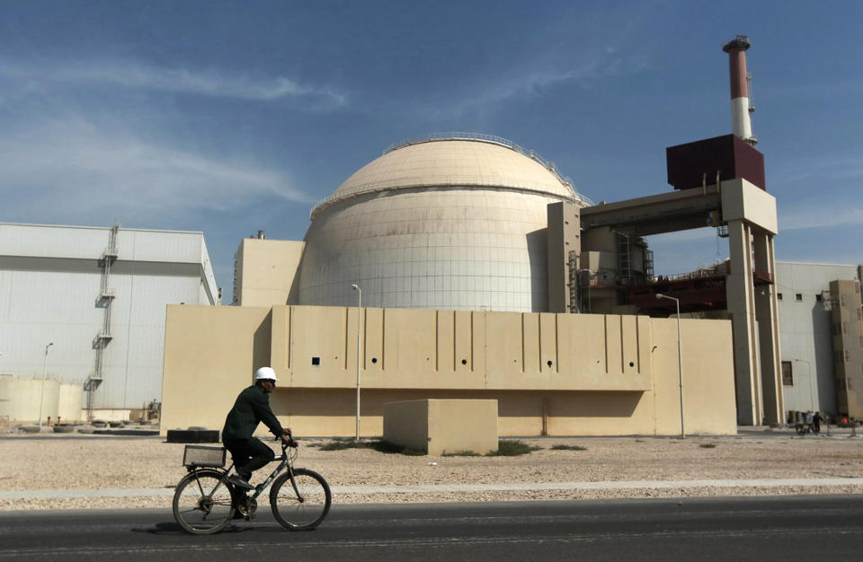 FILE - A worker rides a bicycle in front of the reactor building of the Bushehr nuclear power plant, just outside the southern city of Bushehr, Iran, Oct. 26, 2010. The United Nations' atomic watchdog says it believes Iran has further increased its stockpile of highly enriched uranium in breach of a 2015 accord with world powers. (AP Photo/Mehr News Agency, Majid Asgaripour, file)