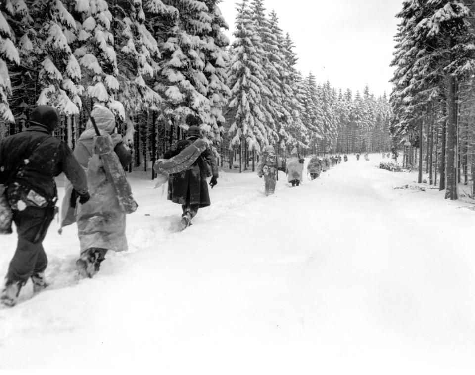 FILE - In this Jan. 28, 1945 file photo, U.S. troops of the 82nd Airborne division travel on a snow-covered fire track in the woods as they move forward in the Ardennes region in Belgium during the Battle of the Bulge. It was 75 years ago that Hitler launched his last desperate attack to turn the tide for Germany in World War II. At first, German forces drove so deep through the front line in Belgium and Luxembourg that the month-long fighting came to be known as The Battle of the Bulge. When the Germans asked one American commander to surrender, the famous reply came: “Nuts!" By Christmas, American troops had turned the tables on the Germans. Veterans are heading and on Monday, Dec. 16, 2019 when they will mix with royalty and dignitaries to mark perhaps the greatest battle in U.S. military history. (Army Signal Corp via AP, File)