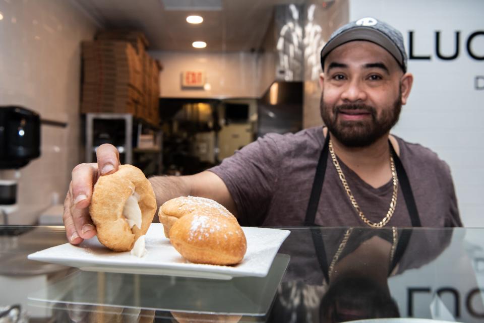 Kitchen manager Romei Pena shows off the cannoli filling of the Italian doughnuts at Lucatelli's Pizzeria in Doylestown, on Monday, January 24, 2022.